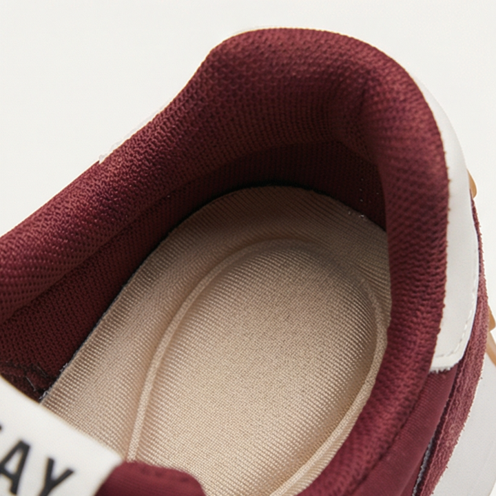 Close up of the padded collar and cushioned interior lining of a burgundy suede sneaker