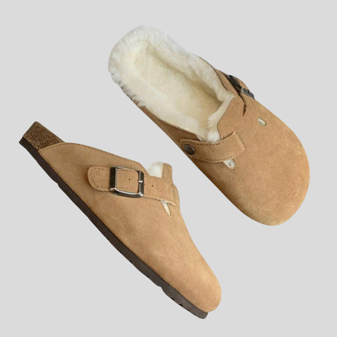 Tan suede clogs with cream shearling lining and a metal buckle strap