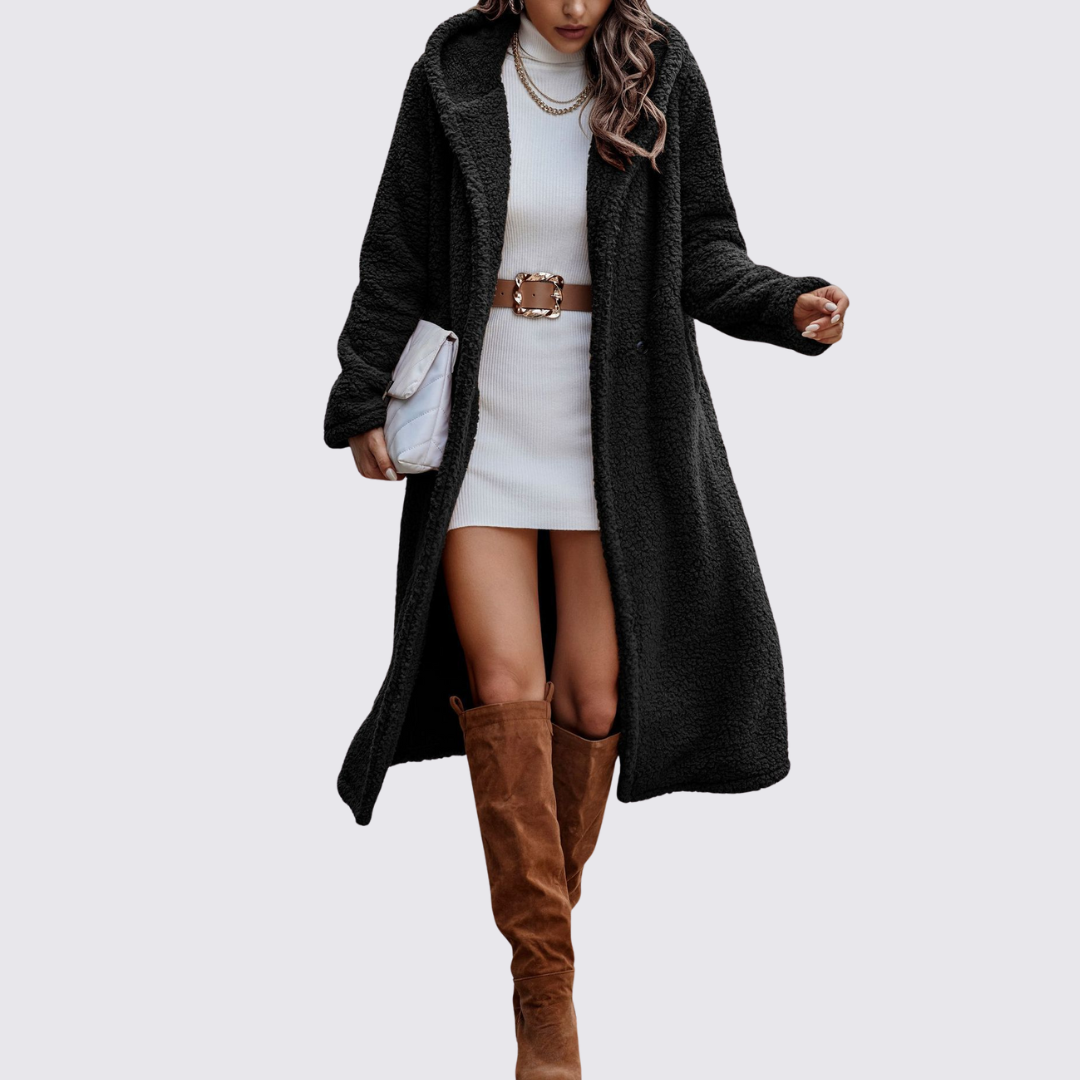 Black longline teddy fleece coat worn open over a white knit dress, full front view
