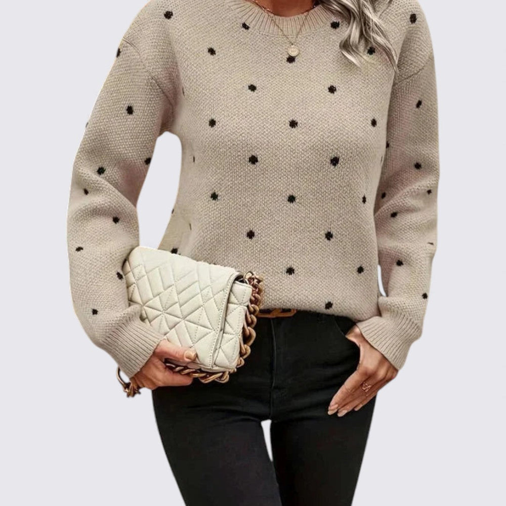 Beige crew neck sweater with black polka dots worn with black jeans, front view