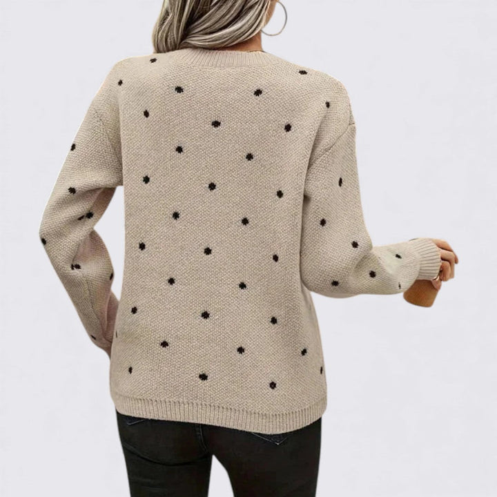 Back view of a beige knit sweater with small black polka dots