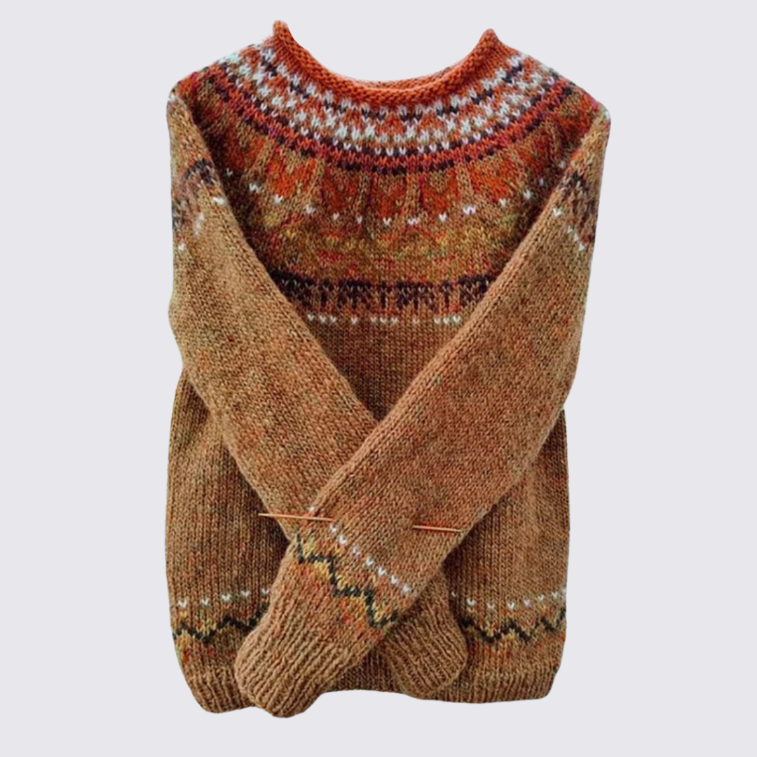 Folded tan knit sweater with a rust and cream Fair Isle patterned yoke and matching trim, flat lay