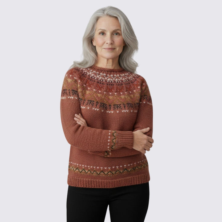 Rust brown fair isle sweater with a patterned yoke and hem, worn with black trousers