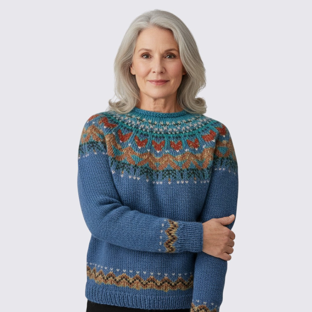 Blue crew neck sweater with a teal and rust patterned yoke, front view on a model