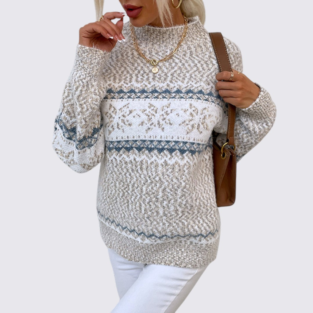 Beige mock neck sweater with blue and white Nordic snowflake stripe pattern, front view