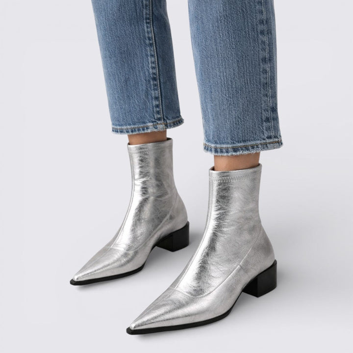 Silver metallic ankle boots with pointed toe and low block heel, worn with jeans