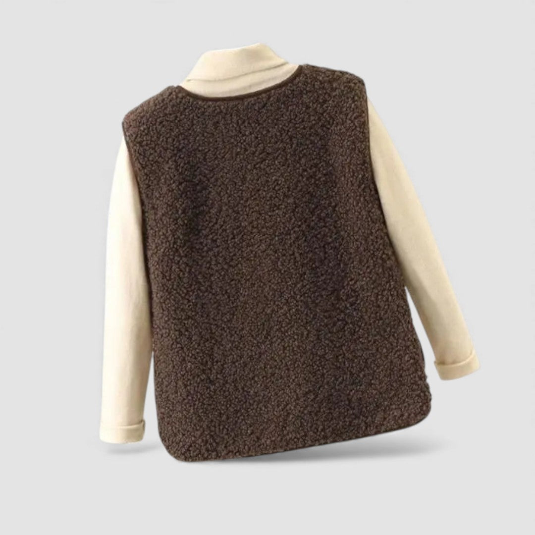 Back view of the brown teddy fleece vest layered over a cream top