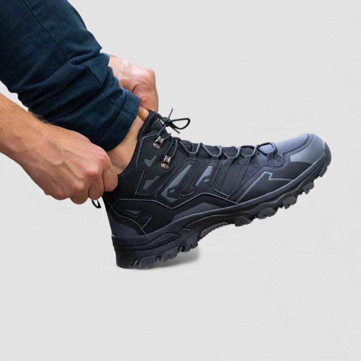 Side view of a dark gray hiking shoe with lugged sole while the laces are tightened