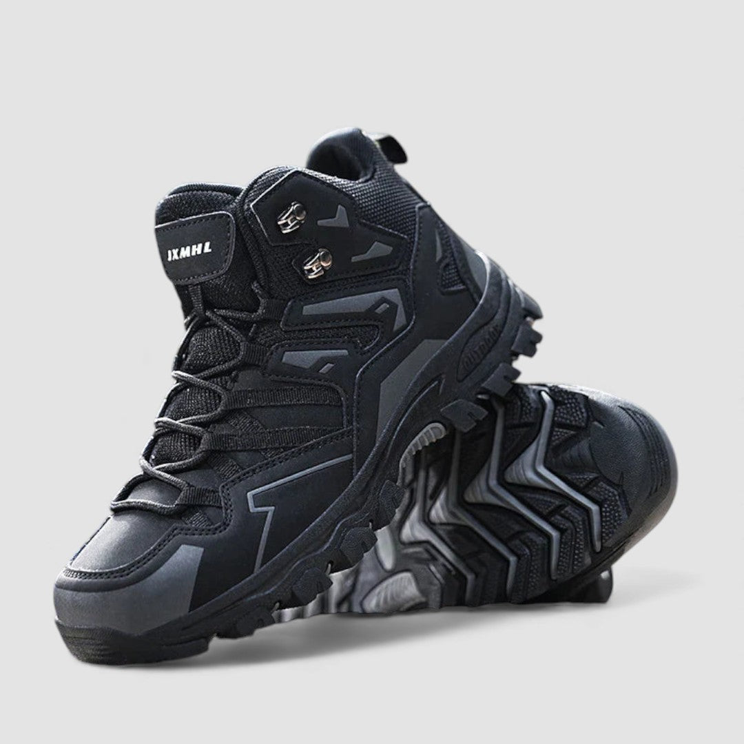 Pair of black hiking shoes on a plain background, one tilted to show the deep tread sole