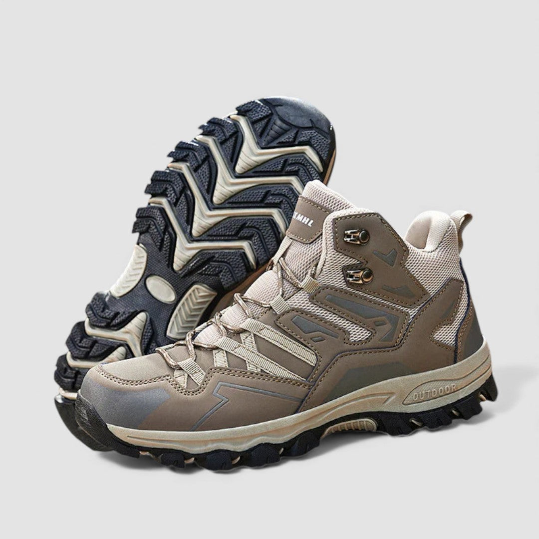 Pair of beige and brown hiking shoes on a plain background with the treaded sole shown