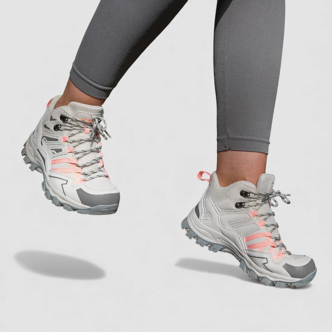 Gray hiking shoes with pink laces and lug soles worn with leggings