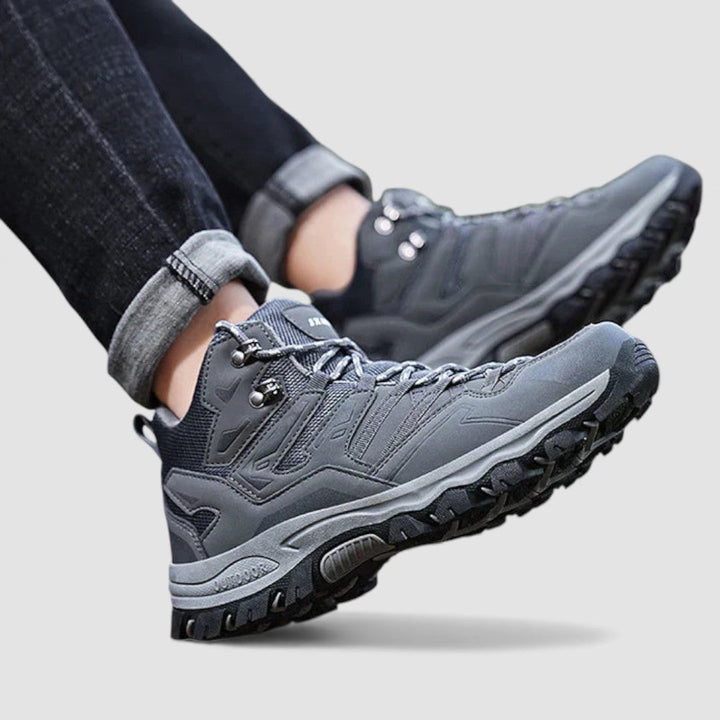 Gray hiking shoes with lace up front and rubber treaded soles, worn with jeans