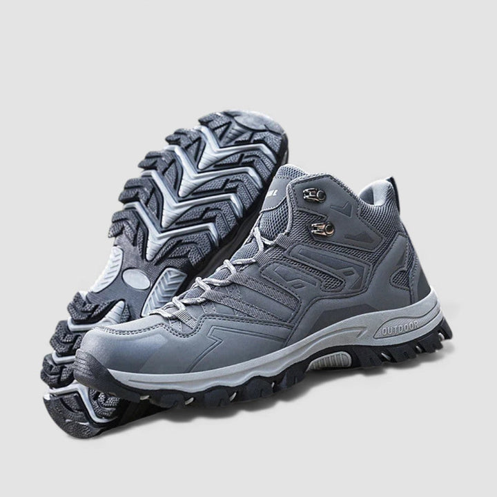 Grey lace up hiking shoes with lugged rubber sole, pair with tread visible