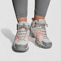 Grey and pink lace up hiking shoes with rugged non slip soles, worn with grey leggings, front view