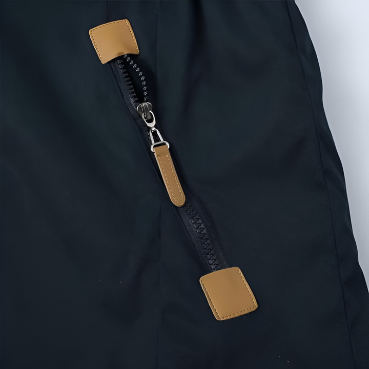 Close-up of the navy parka side zip pocket with tan leather pull tab