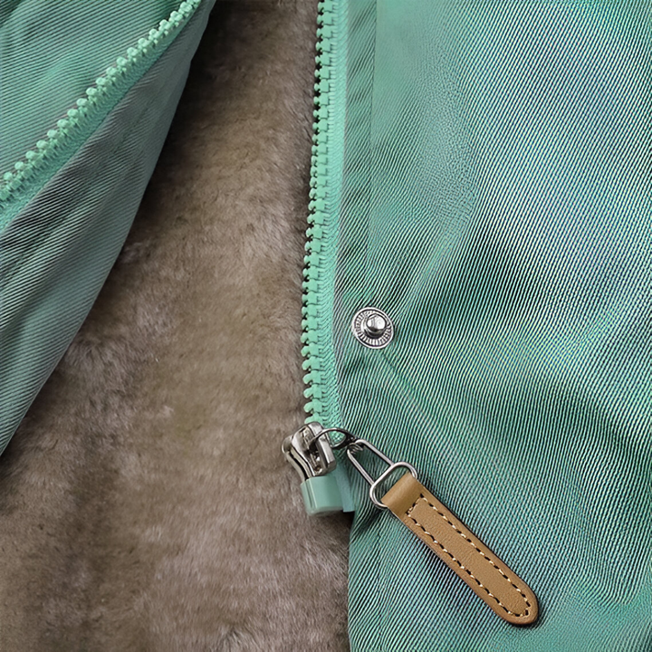 Close up of a mint green jacket zipper, snap button and soft fur lining