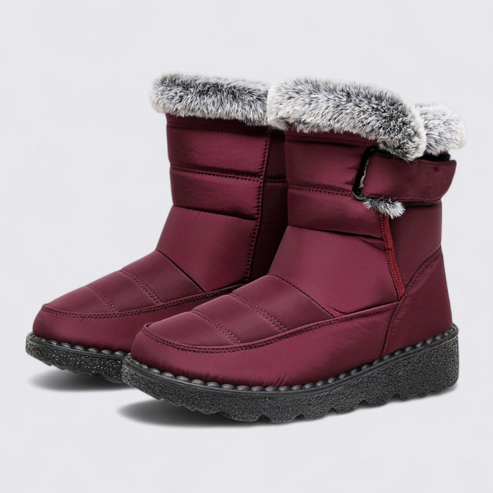 Pair of burgundy padded snow boots with grey faux fur trim and a thick treaded sole
