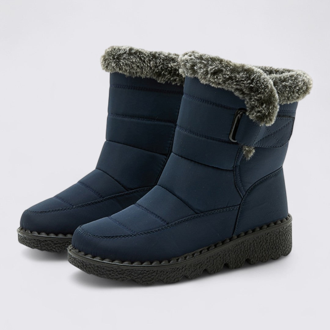 Pair of navy padded snow boots with faux fur cuff and grip sole