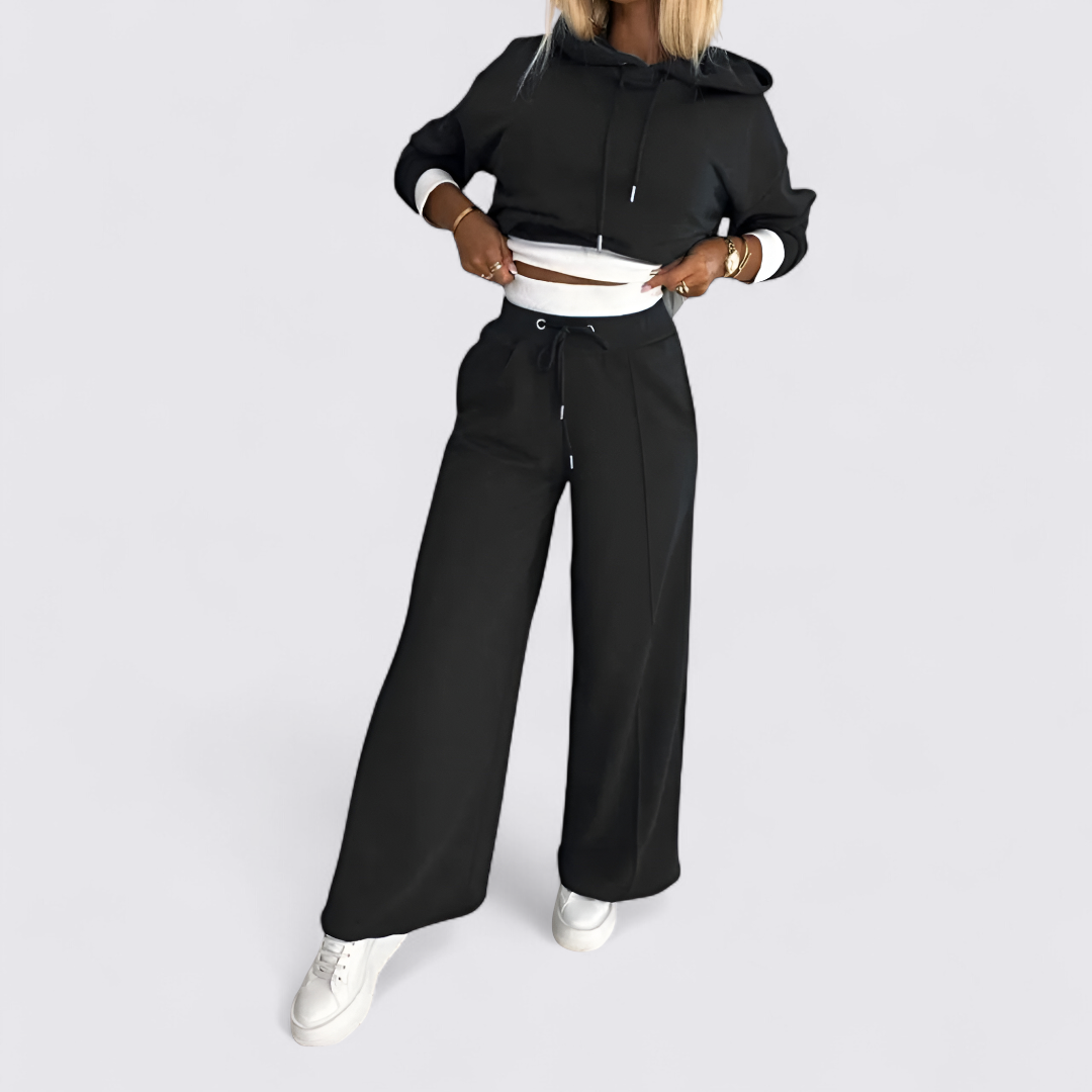 Black cropped hoodie and wide leg pants set worn with white sneakers, full view