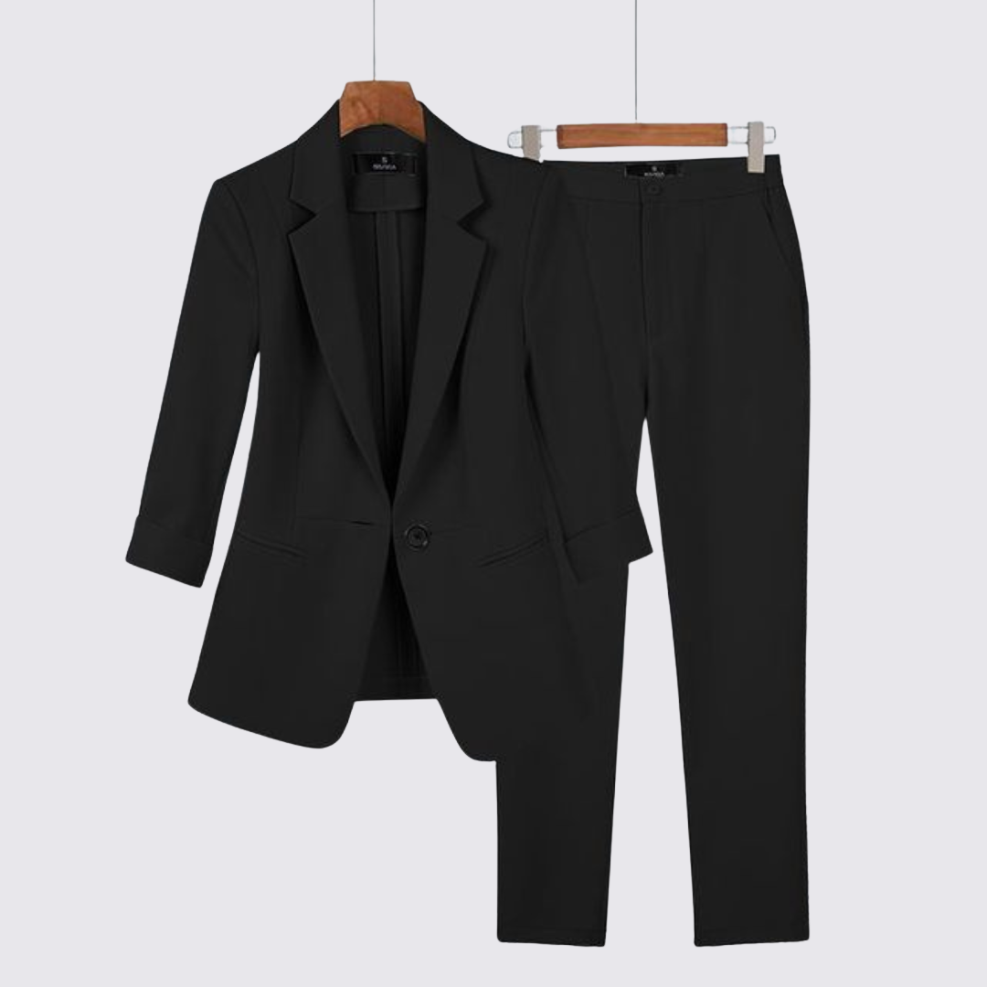 Black single button blazer and matching tapered trousers shown on hangers