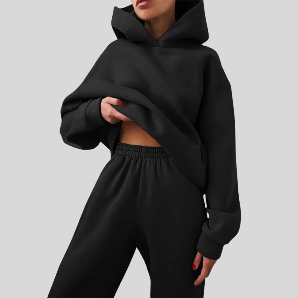 Black cropped hoodie and matching joggers worn together, front view on a plain background