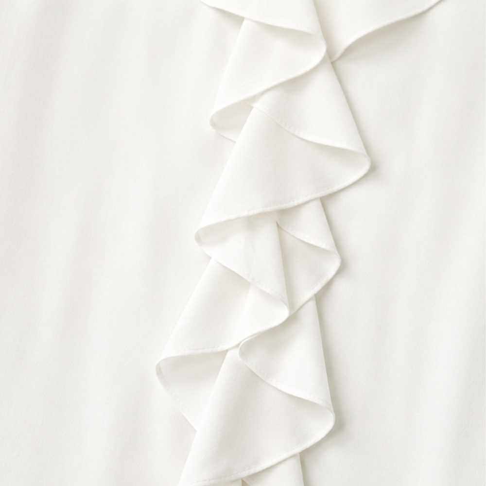 Close up of the cascading ruffle placket on a white blouse