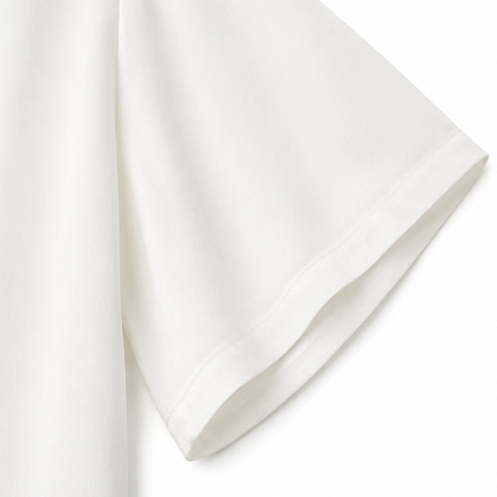 Close-up of the flared white sleeve and stitched hem of the blouse