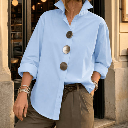 Light blue asymmetric button front blouse with oversized round buttons, front view