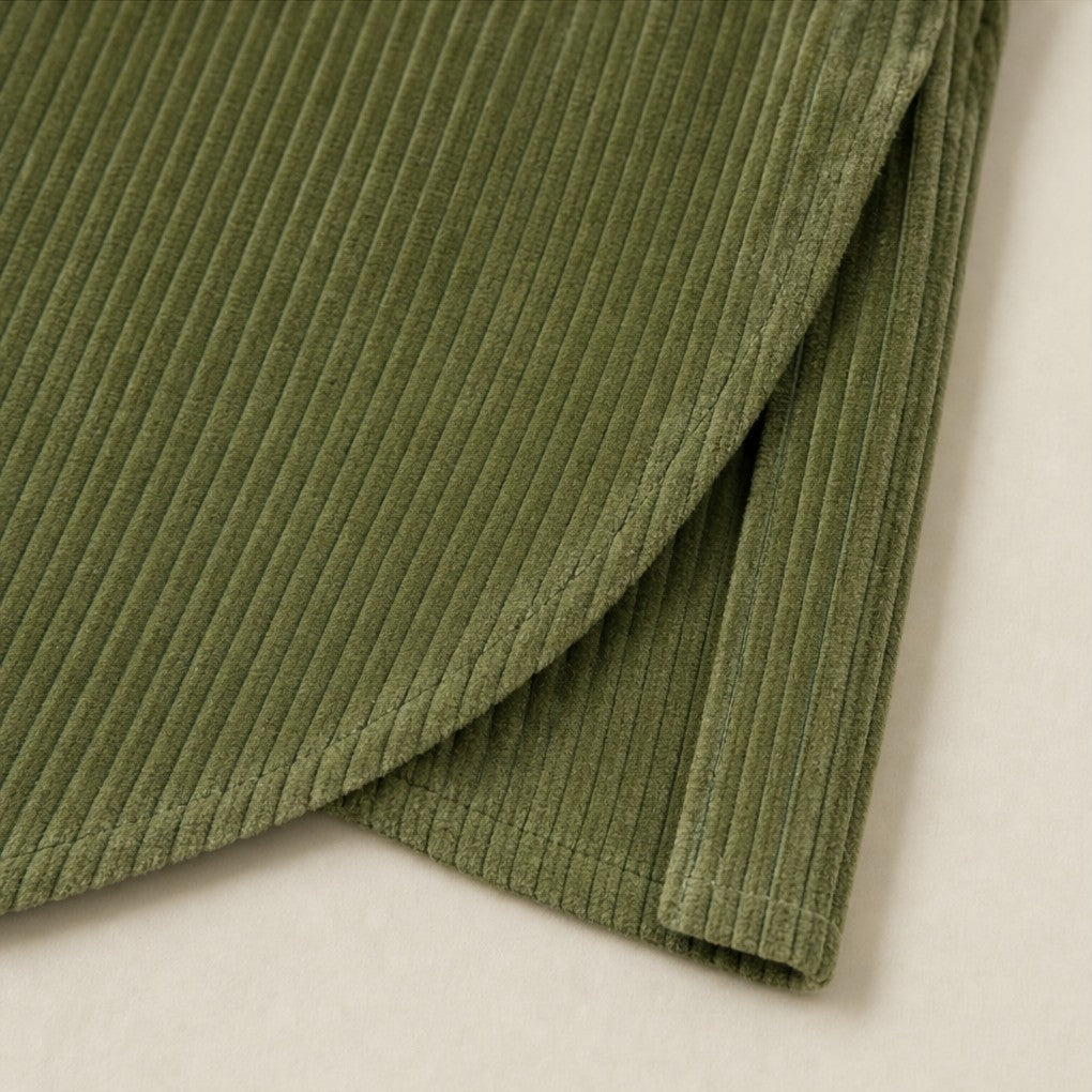 Close-up of the curved crossover hem of the corduroy top
