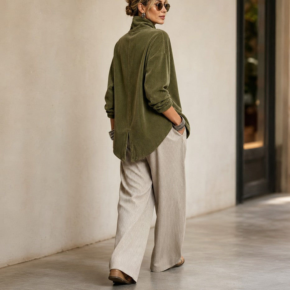 Olive green corduroy top, back view walking in wide cream pants