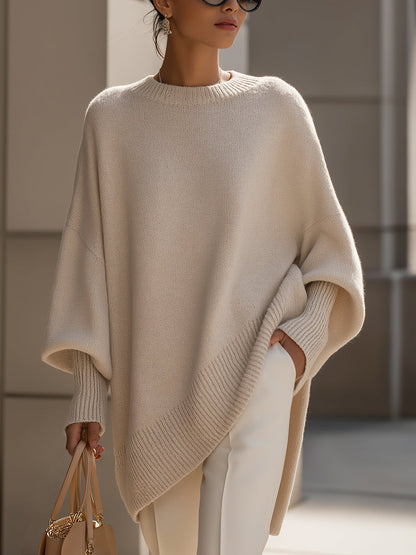 Beige oversized poncho sweater with an asymmetric hem, front view