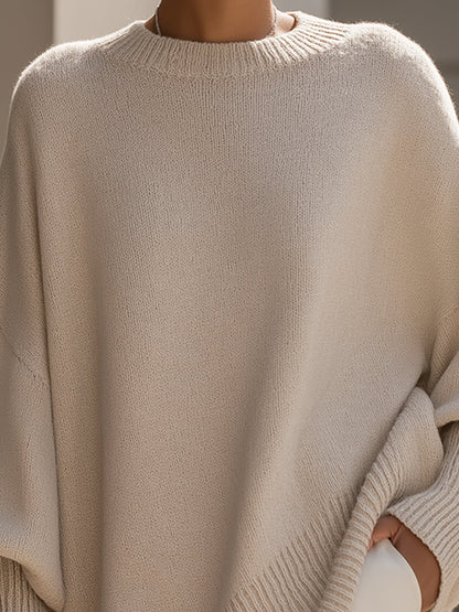 Close-up of the crew neck and soft knit of the beige poncho sweater