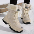 Beige lace up boots with a cream cuff on a cleated sole in snow