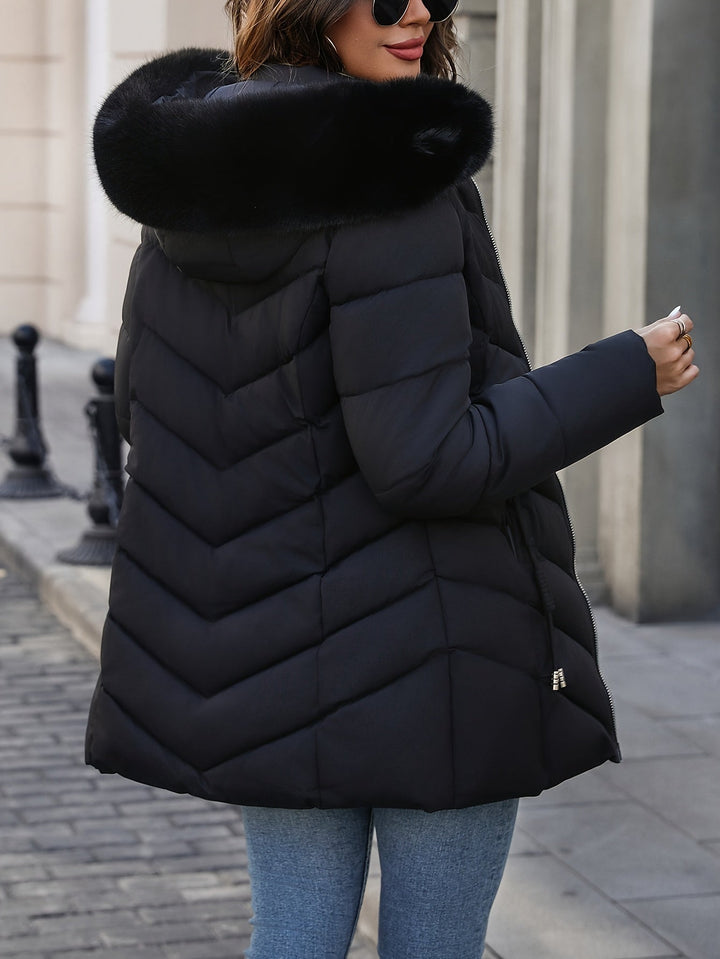 Black quilted coat seen from the side with the fur hood up