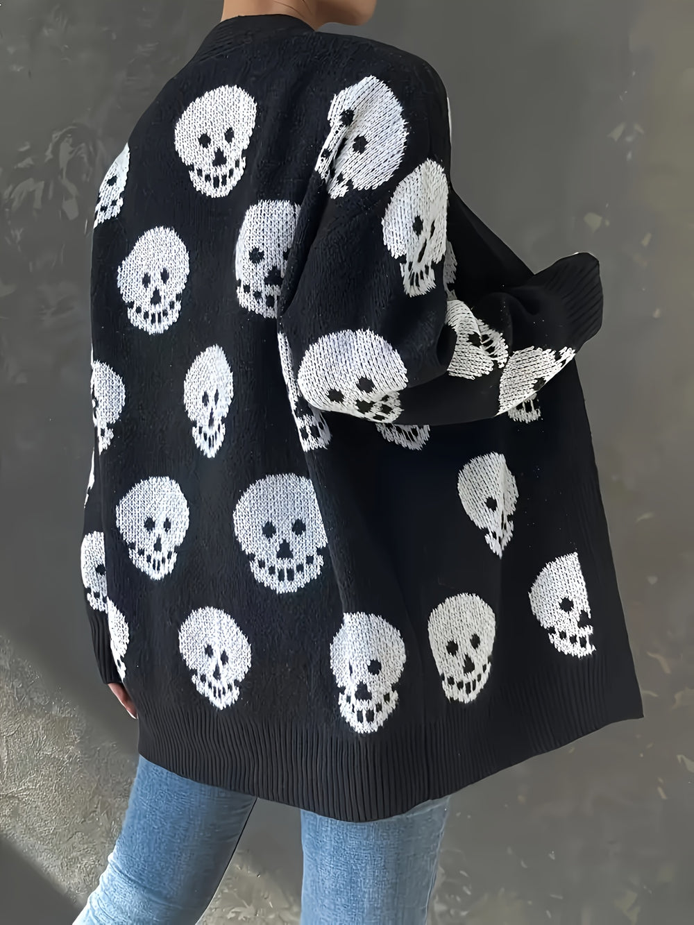 Back of a black longline cardigan with a white skull pattern all over