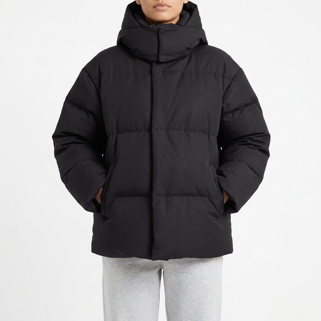 Black oversized puffer coat with the hood pulled up, front view