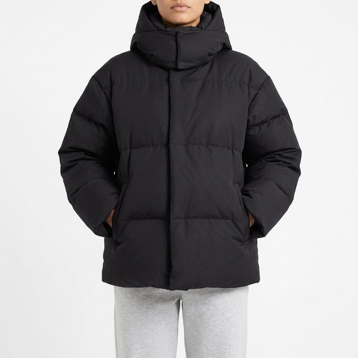 Black oversized puffer coat with the hood pulled up, front view