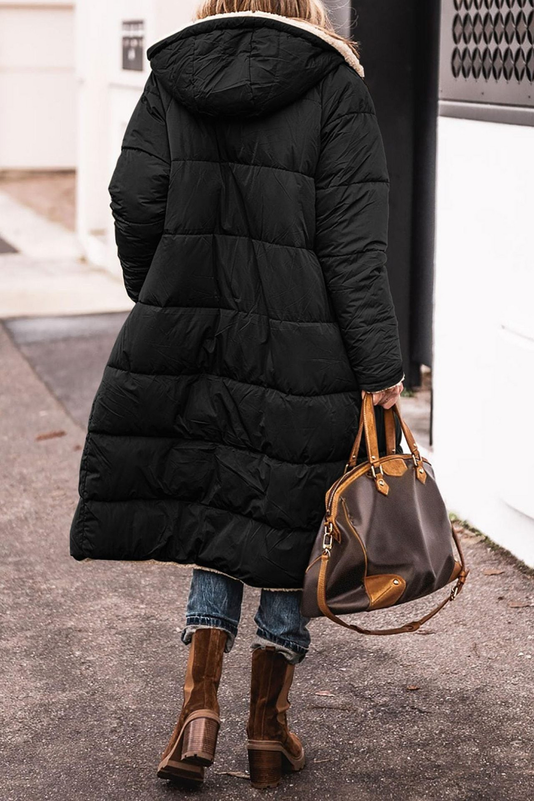 Back view of a long black quilted coat with a sherpa lined hood
