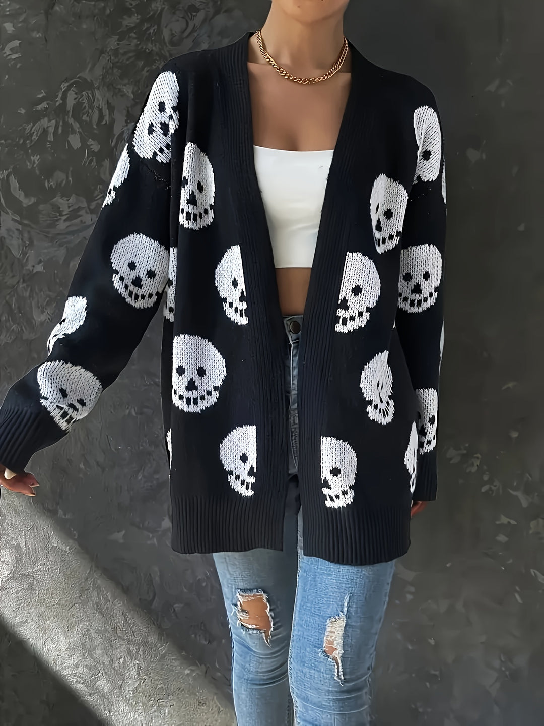 Black longline open front cardigan with white skull pattern, worn over a white top and jeans