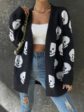 Black longline open-front cardigan with an allover white skull print, worn with jeans