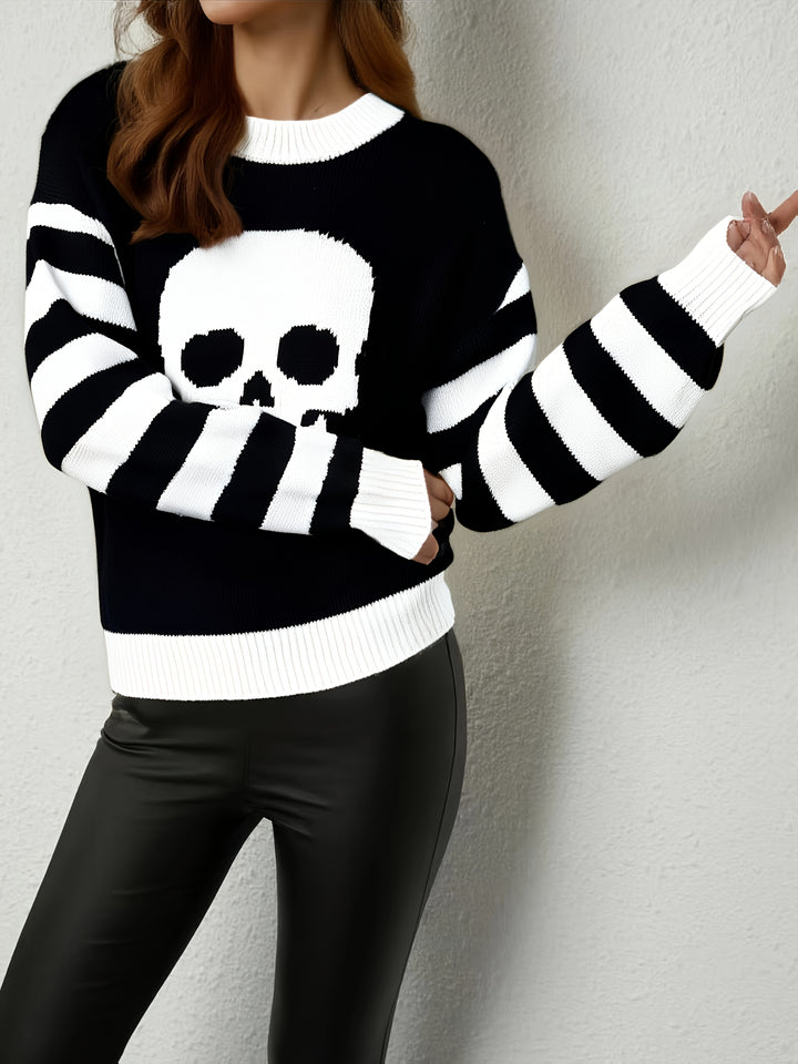 Black knit sweater with a large white skull on the chest and striped sleeves, side angle