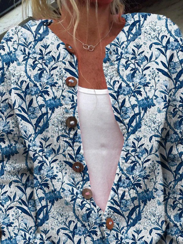 Close up of a blue and white floral print button cardigan over a white top