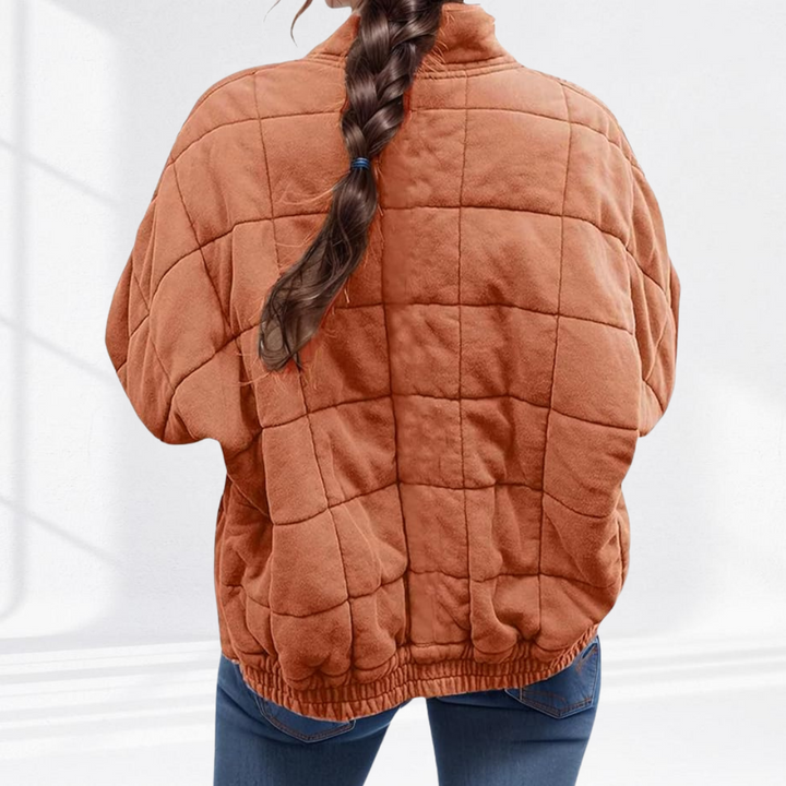 Rust box quilted bomber jacket showing the elasticated hem, back view
