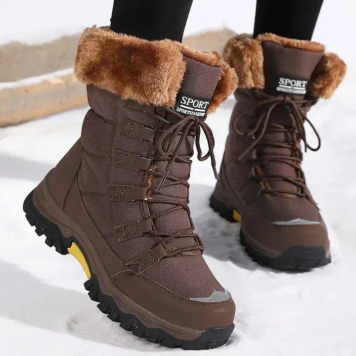 Brown lace up boots with a brown cuff on a cleated sole in snow