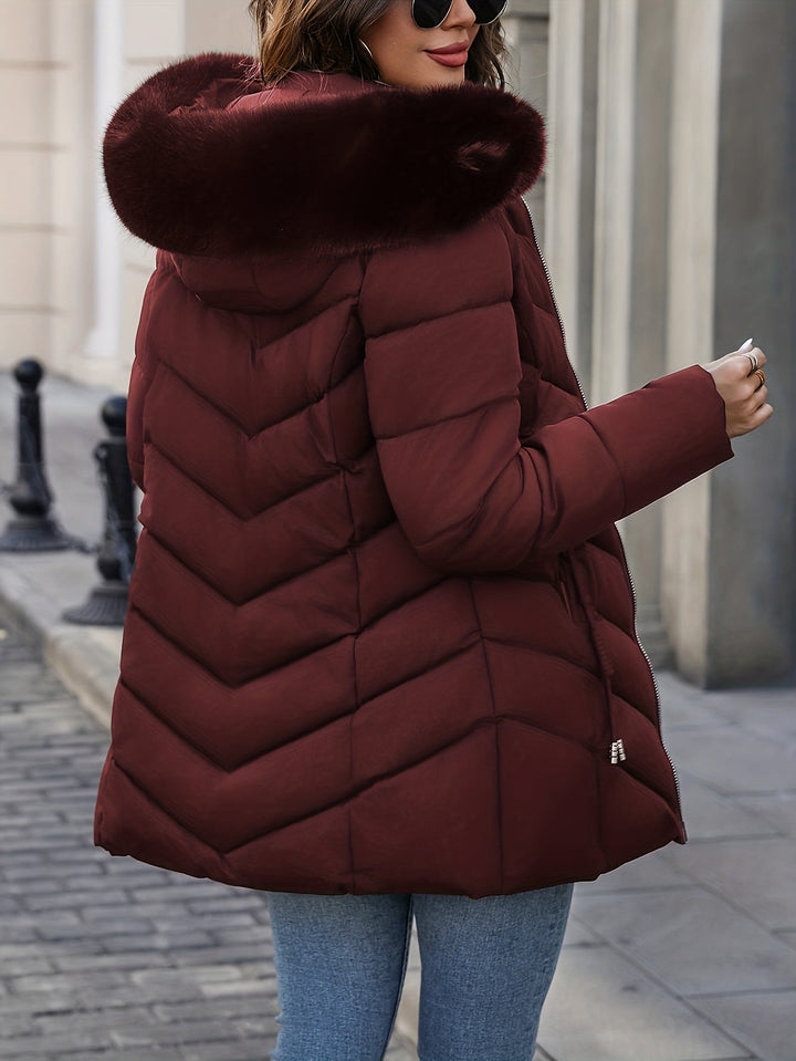 Burgundy quilted coat seen from the side with the fur hood up