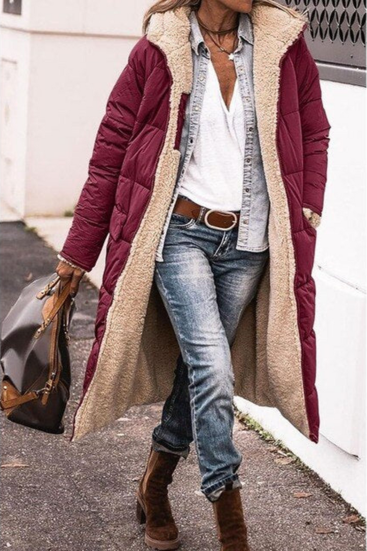 Burgundy longline quilted coat with cream faux shearling lining, worn open outdoors