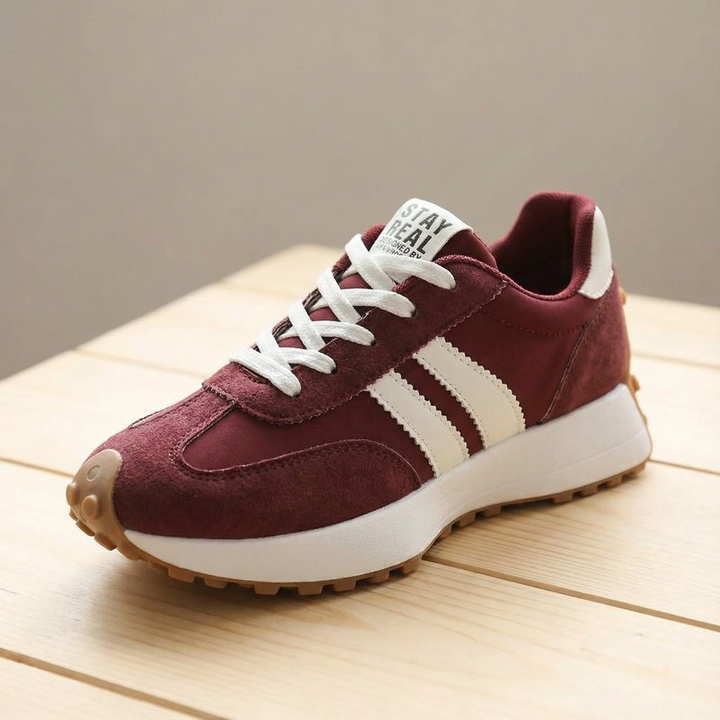 Burgundy suede sneaker with cream side stripes and gum sole, angled view