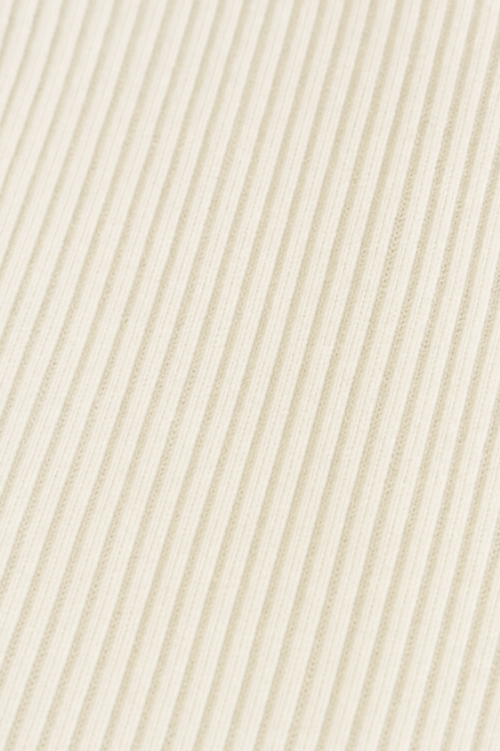 Ribbed knit texture on a cream longline coat