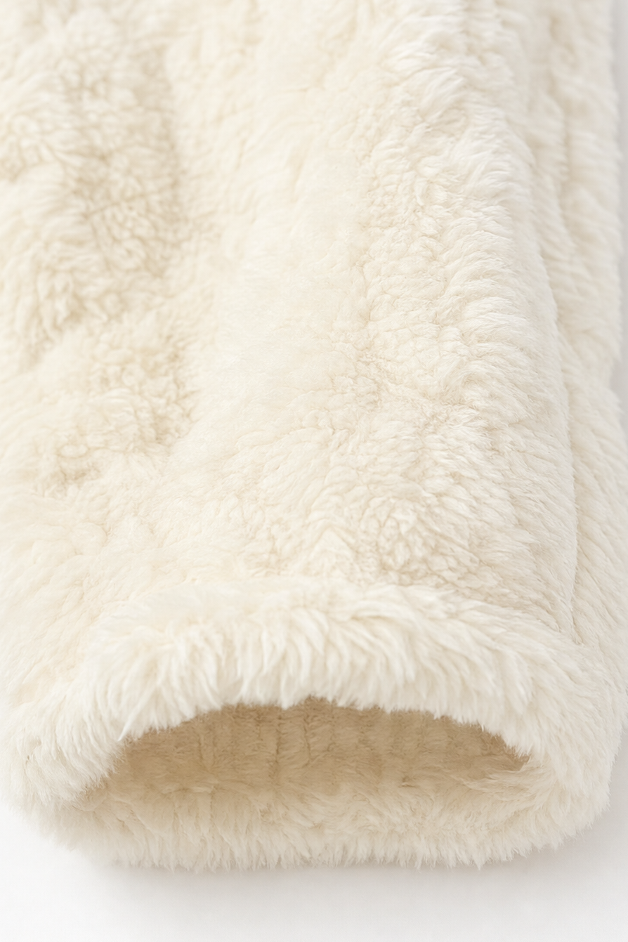 Rolled cream cable fleece showing the cable knit texture