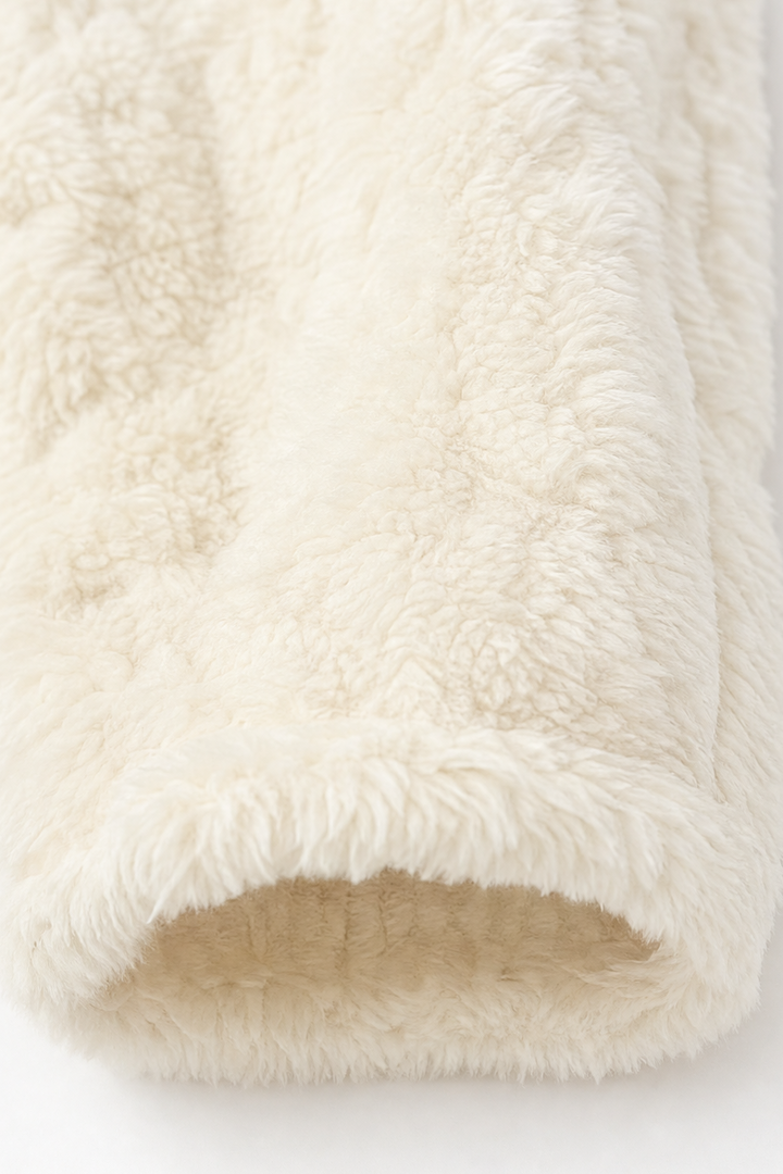 Rolled cream cable fleece showing the cable knit texture
